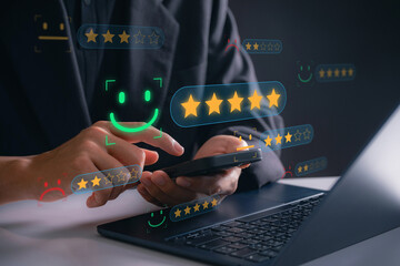 Customer satisfaction review Concept. Businessman using smartphone to rate service with digital star system and smiley face interface, analyzing user feedback to improve experience