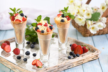 Japanese crepes with whipped cream filling, strawberries, blueberries, almond petals, garnished with mint.  