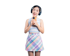 An excited young Asian woman with headphones, using her smartphone as a microphone to sing karaoke...