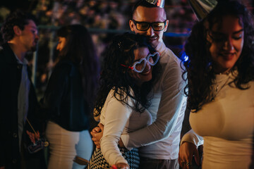 A lively gathering of friends at a nighttime celebration featuring cheerful mood, fashionable...