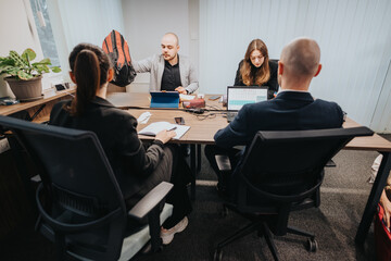 A group of colleagues working collaboratively in a corporate office setting, surrounded by laptops...