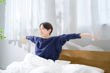 A Japanese woman relaxing in bed in the morning
