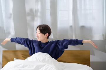 A Japanese woman relaxing in bed in the morning