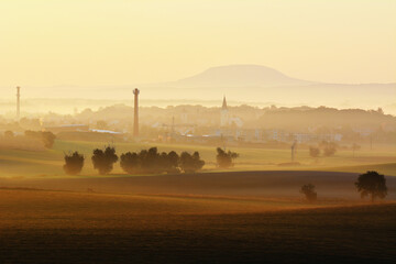 Little Town Church and Chimney Silhouetted in Misty Morning Golden Light