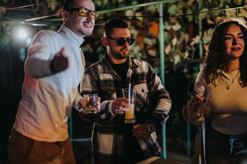 Friends enjoying a warm evening together, drinking beverages and socializing outdoors with smiles. The ambiance evokes fun and connection, ideal for celebrations and gatherings.