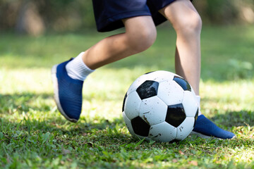 Child Dribbling Soccer Ball: Active Playtime on Grass