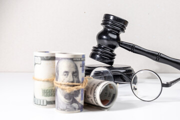 A gavel set behind bundles of money conveys the concept of financial consequences, court verdicts, or legal disputes involving monetary resolutions.

