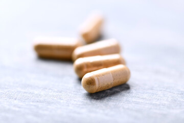 Korean Ginseng capsules. Concept for a healthy dietary supplementation. Wooden background. Soft focus. Close up.	