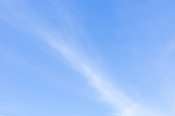 Gentle, dreamy clouds form abstract patterns across a calm blue sky, evoking peace, imagination,...
