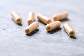 Korean Ginseng capsules. Concept for a healthy dietary supplementation. Wooden background. Soft focus. Close up.	