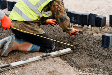 Construction workers are laying bricks to create a landscaped garden path