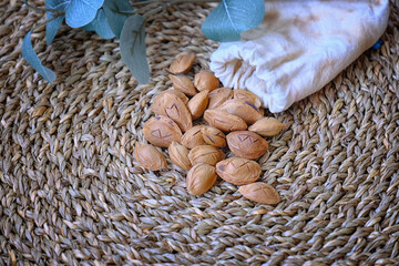 A mystical still life featuring apricot stones engraved with runes, spilling from a linen pouch...