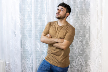 man with crossed arms looking up thoughtfully