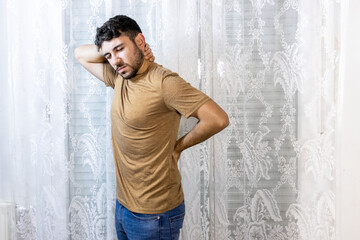 Man holding neck and back in pain on white background