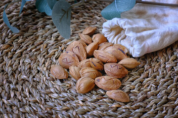 A mystical still life featuring apricot stones engraved with runes, spilling from a linen pouch...