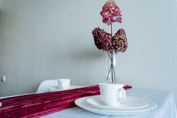 A beautifully arranged dining table adorned with elegant plates and a stunning vase filled with...