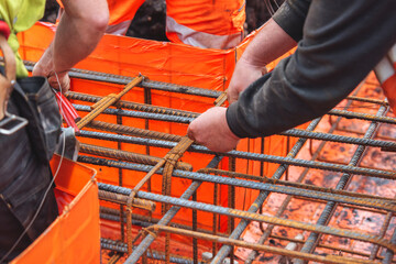 Close-up of steel fixer construction worker preparing and assembling reinforcement rebar on...