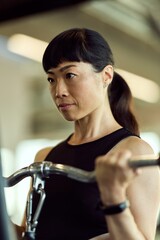 Focused Woman Exercising on Gym Equipment, Building Strength and Determination