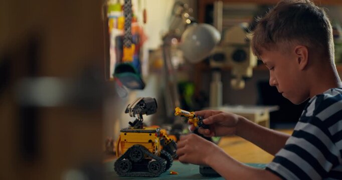A child builds robot from construction kit. Home leisure