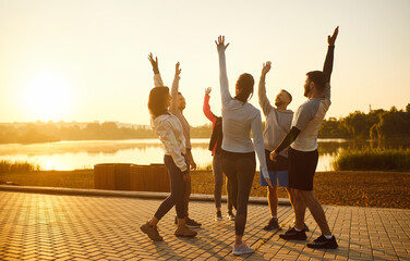 Happy gesture of runners with hands up, excited athletes group standing in circle to celebrate...