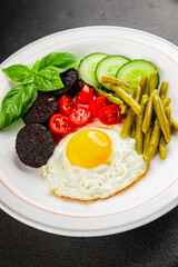 English breakfast fried egg, black pudding, vegetables, beans fresh delicious gourmet food background on the table rustic food top view copy space