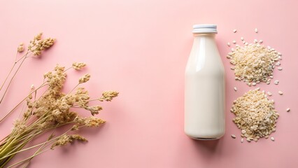 A bottle of creamy rice milk with dried grains and delicate dried flowers on a pink background