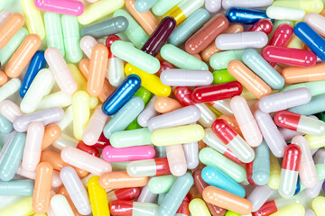 A vibrant, multi-colored background of assorted pharmaceutical capsules. This medicine texture is ideal for concepts of healthcare, drug production, and the pharmacy industry.