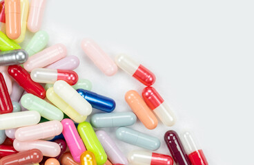 A pile of assorted pharmaceutical medicine pills and colorful capsules creating a frame with copy...