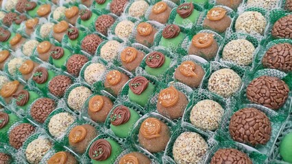 Vibrant assortment of traditional Brazilian sweets like brigadeiro, beijinho, and nut-covered truffles. A colorful display of confectionery for birthday parties, weddings, or festive events.