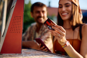 Close up of woman paying contactless at music festival in summer.