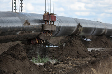 Fototapeta premium Installation of a huge industrial gas pipe line on a field