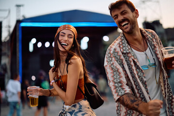 Cheerful couple dancing on summer music festival.