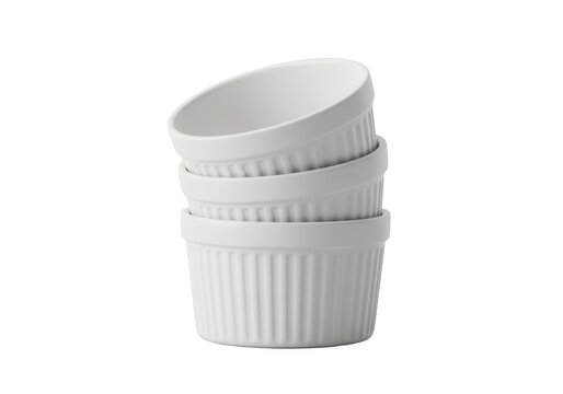 Stacked white ramekins on a plain surface for culinary decoration