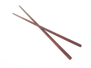 A pair of wooden chopsticks placed on a white background. Two wooden chopsticks made of wood....