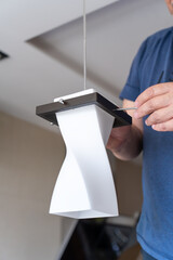 Electrician installs modern pendant lamps in stylish kitchen.