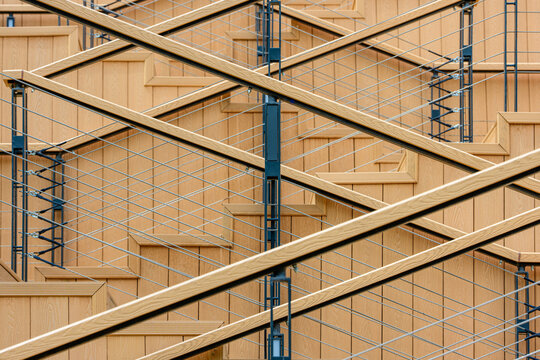 Modern diagonal wooden staircase with metal cable railing, architectural abstract background, close-up of geometric pattern of steps and rails in contemporary urban design.