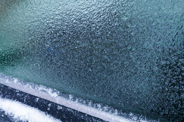 Close-Up of Car Window Covered with Thick Frost and Ice Crystals in Winter Morning, Frozen Surface...