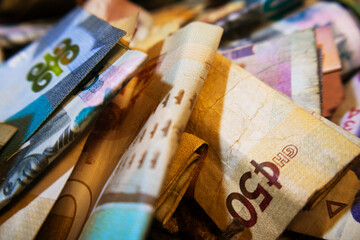 Vibrant colorful photo of mixed Ghanaian cedi notes currency money spread scattered on table desk ground floor surface background