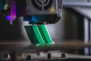 Modern 3d printer creating a green plastic object using innovative technology in a laboratory setting, showcasing the advancements in additive manufacturing
