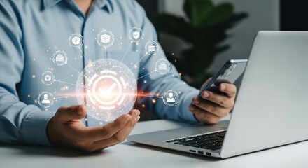 Photo of a businessman holds a glowing digital sphere of interconnected icons representing business processes and data, while using a laptop and smartphone