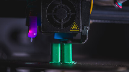 Modern 3d printer creating a green plastic object using innovative technology in a laboratory setting, showcasing the advancements in additive manufacturing