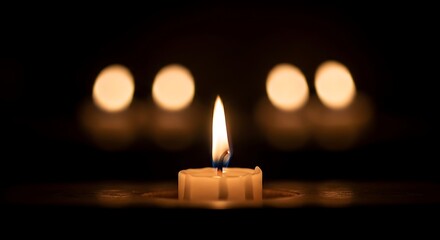 A single candle flame glowing brightly in a dark background, with blurred lights.