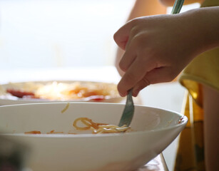 Child Eating Spaghetti - Child's Hand and Fork Finishing Last Bites of Spaghetti in a White Bowl