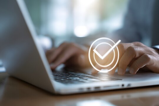 Hands typing on a laptop with a glowing check mark overlaying the keyboard close up and blurry background - Powered by Adobe