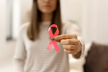 Woman showing pink ribbon supporting breast cancer awareness campaign
