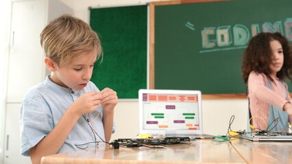 Girl standing while fixing electronic board by using screwdriver. American student and happy...