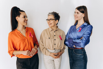 Women of different ages and ethnicities wearing pink ribbons are talking about breast cancer