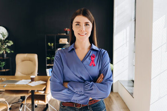 Businesswoman wearing pink ribbon supporting breast cancer awareness in office