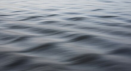 Naklejka premium Close-up view of water surface with gentle waves creating a soft, blurred effect.