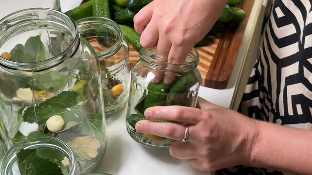 Caucasian woman preparing homemade pickles with cucumbers, garlic, and spices perfect for canning season, preserving, and culinary arts